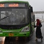 Photo:  A woman getting on to a DTC bus while it rains on a National Highway near Pandav Nagar in New Delhi, India, (Ajay Aggarwal /HT PHOTO)