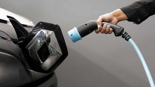 An EV owner holds a cable to charge a Renault electric vehicle. (File Photo) (REUTERS)