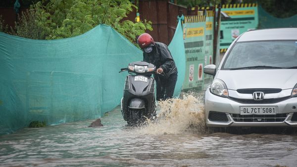 A waterlogged stretch at Pragati Maidan in New Delhi as commuters try to wade through the water. (Sanchit Khanna/HT PHOTO)