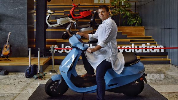 Bhavish Aggarwal, Co-founder and CEO of Ola, poses for a photograph with the new Ola electric scooter during its launch at the Ola headquarters in Bangalore on August 15, 2021. (AFP)
