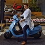 Bhavish Aggarwal, Co-founder and CEO of Ola, poses for a photograph with the new Ola electric scooter during its launch at the Ola headquarters in Bangalore on August 15, 2021. (AFP)
