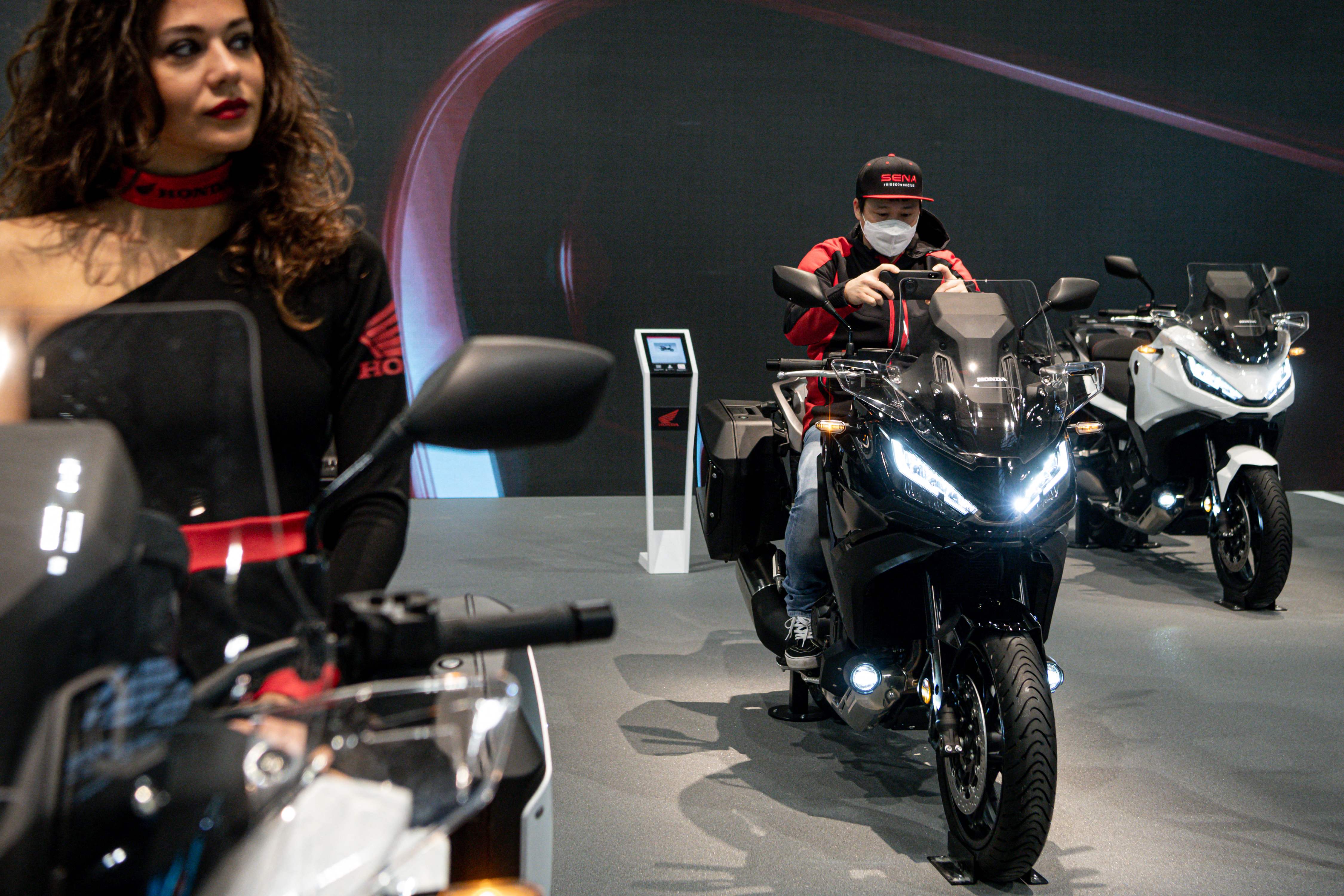 A man takes a picture of a Honda NT 1100 on display on the Honda stand at EICMA. (AFP)