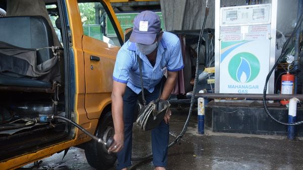 A CNG pump station attendant filling CNG gas in a car amid CNG price rise by 2.58 paise per kg. (HT PHOTO)