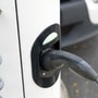 A charging plug is connected to an electric vehicle at a charging station. (File photo used for representational purpose only) (Bloomberg)