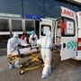 Red cross ambulance staff wearing protective suits to protect from the coronavirus disease load a stretcher into an ambulance, outside the main press centre ahead of the Beijing 2022 Winter Olympics. (REUTERS)