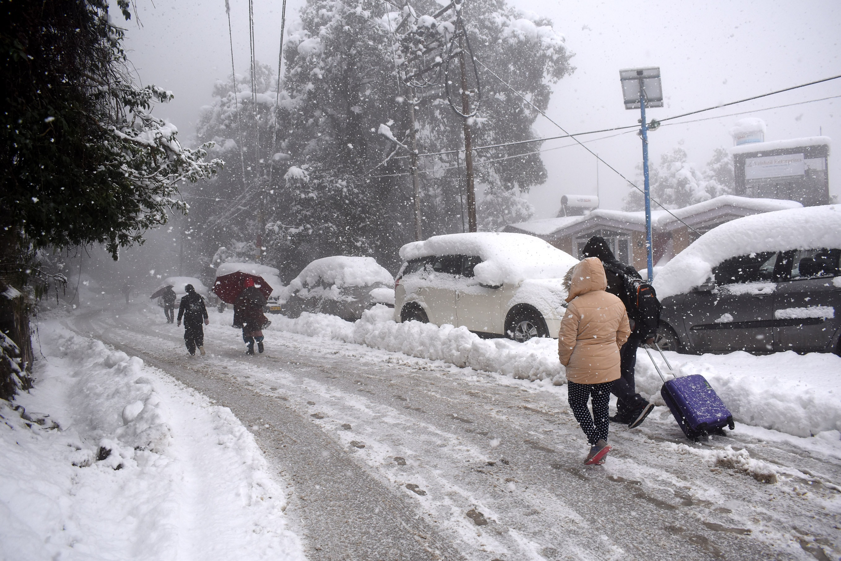 Tourists walk during heavy snowfall on Sanjauli-IGMC Hospital road near Sanjauli in Shimla. Tourists walk during heavy snowfall on Sanjauli-IGMC Hospital road near Sanjauli in Shimla.