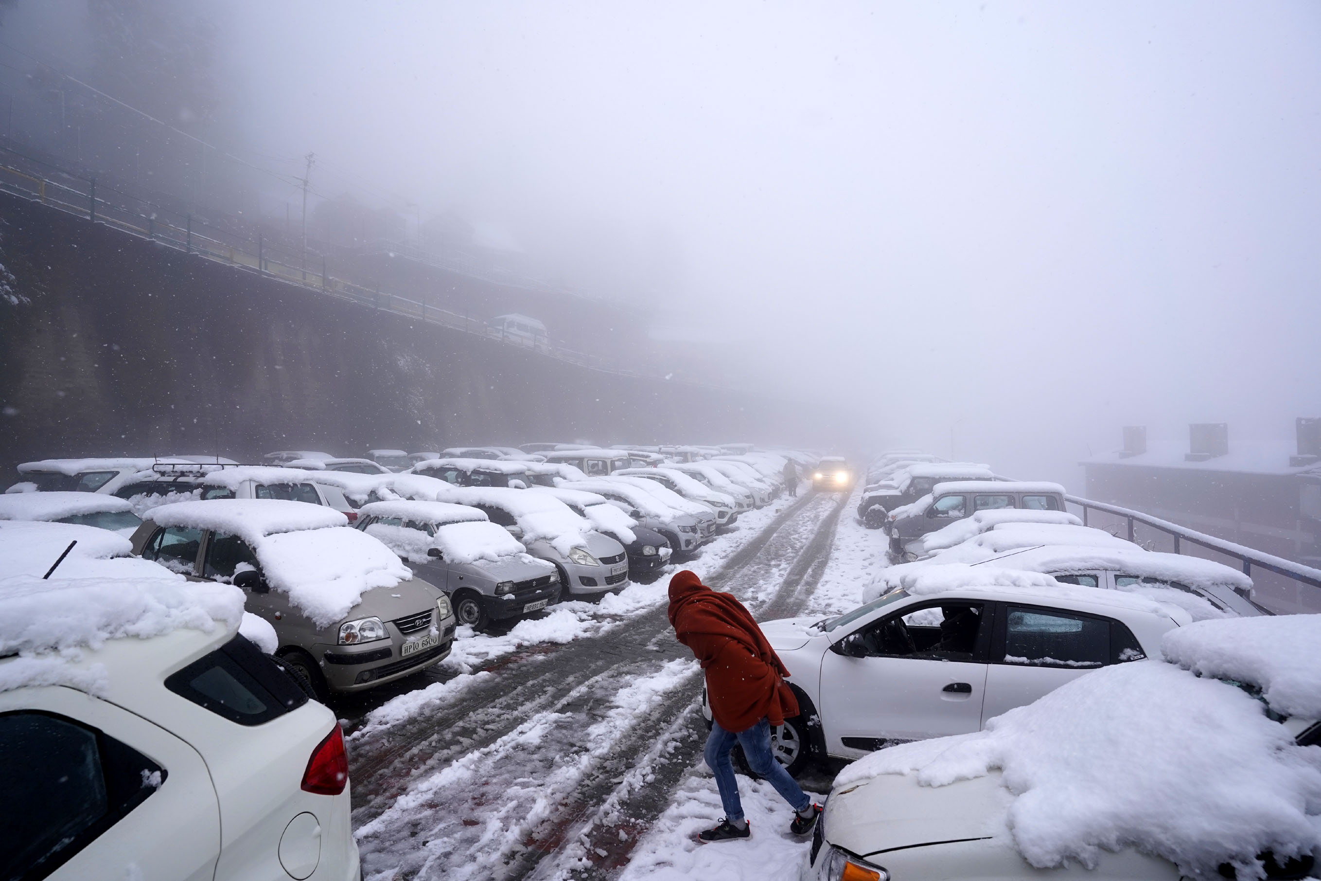 A view of the parked vehicles covered under thick sheet of snow during a heavy snowfall at the Old Bus Stand in Shimla A view of the parked vehicles covered under thick sheet of snow during a heavy snowfall at the Old Bus Stand in Shimla