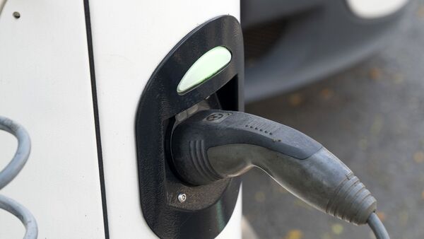 A charging plug is connected to an electric vehicle at a charging station. (File photo used for representational purpose only) (Bloomberg)
