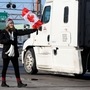 A woman attends a protest against Covid-19 vaccine mandates, as vehicles block the route leading from the Ambassador Bridge linking Detroit and Windsor. (REUTERS)
