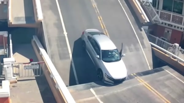 The Honda Accord SUV was trying to cross the bridge. It got stuck after passing under the first gate just as it was closing. (Image courtesy: YouTube/WPTV)