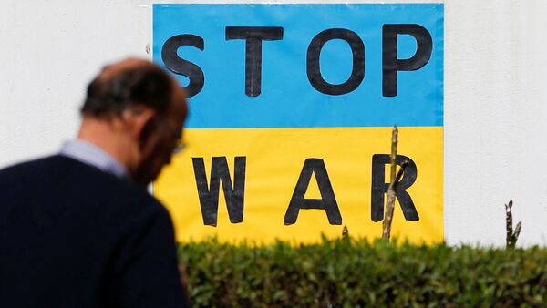 A man walks in front of the embassy of Ukraine next to a sign during a conference for the situation in Ukraine. (REUTERS)