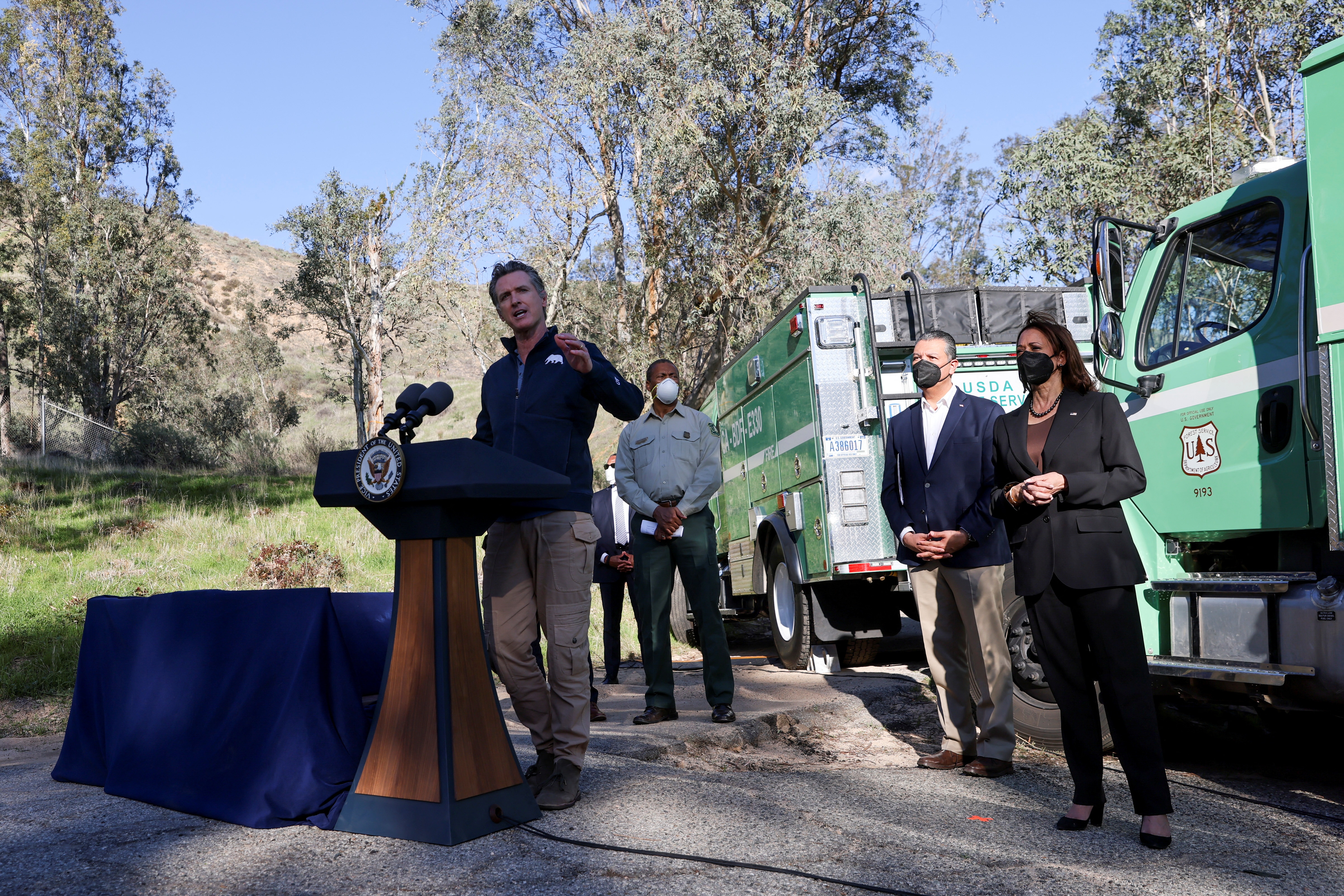 File photo: California Governor Gavin Newsom delivers remarks as US Vice President Kamala Harris looks on as they tour the US Forest Service Del Rosa Fire Station.