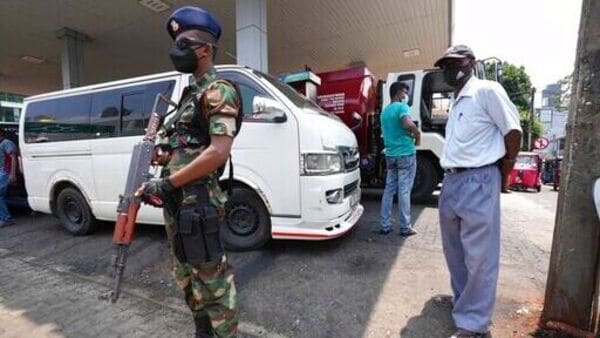 A Sri Lankan army soldier secures a fuel pump as people wait to buy diesel in Colombo. (AP)