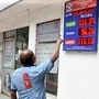 A staff at a petrol station points to the rising fuel prices as they reach an all-time high, in Kolkata on Thursday. (ANI Photo) (Utpal Sarkar)