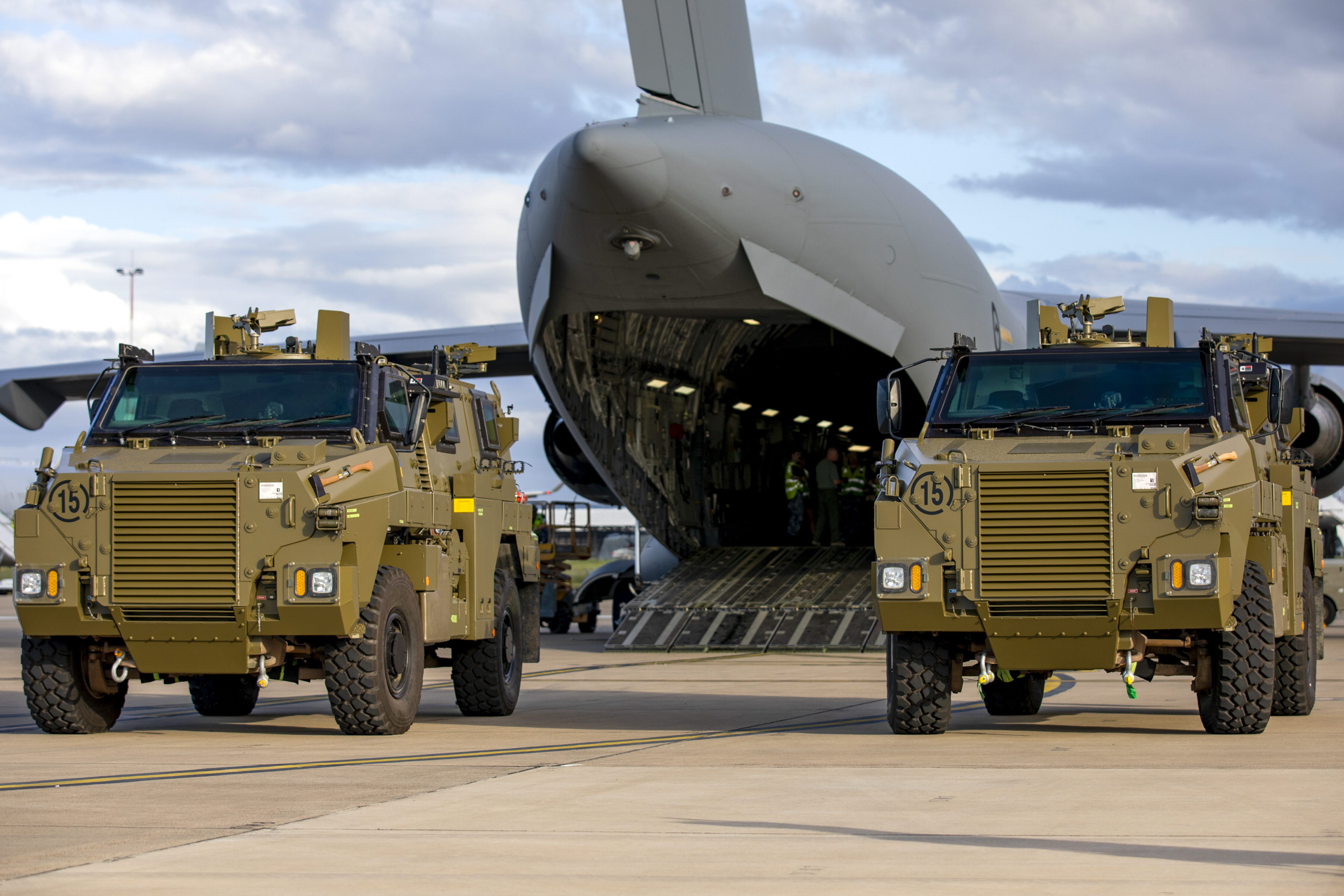 In this photo provided by the Australian Defense Force, two Bushmaster protected mobility vehicles bound for Ukraine wait to be loaded onto a C-17A Globemaster III aircraft.