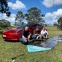 University of Newcastle Centre for Organic Electronics facility manager and project manager for Charge Around Australia Ben Vaughan, University of Newcastle research associate Matthew Bergin, Charge Around Australia project lead and inventor of printed solar panels Paul Dastoor and chief designer Michael Dickinson are pictured near a printed solar panel and a Tesla car, in Gosforth, Australia. (REUTERS)