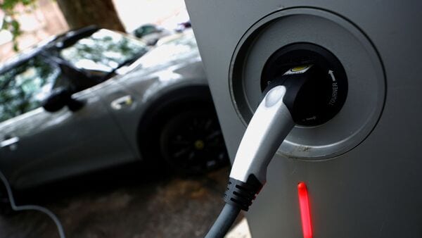 FILE PHOTO: An electric car is seen plugged in at a charging point for electric vehicles. (REUTERS)