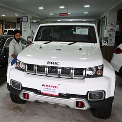 An employee cleans an imported vehicle at a car showroom in Islamabad.
