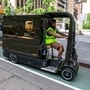 UPS worker Dyghton Anderson peddles an eQuad electric bike in a bicycle lane while delivering packages, in New York. (AP)