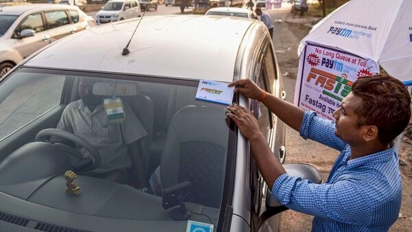 Representational image of a worker fixing a FASTag sticker on the windscreen of a car, at Vashi Toll Plaza. (PTI Photo)(PTI11_29_2019_000194B) (PTI)