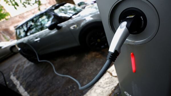 An electric car is seen plugged in at a charging point for electric vehicles. (REUTERS)