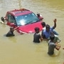 People pull a car through a water-logged road following torrential rains in Bengaluru, (HT_PRINT)
