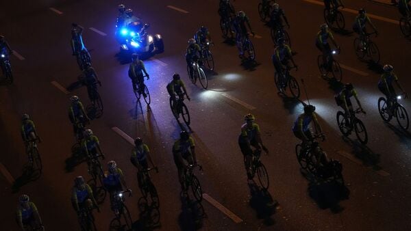 A police motorcycle follows a group of cyclists during the Dubai Ride A police motorcycle follows a group of cyclists during the Dubai Ride