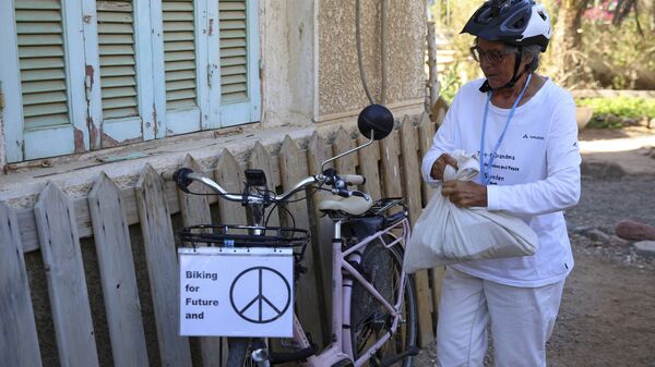 Dorothee Hildebrandt, 72, prepares her bike at her host's apartment to ride to the U.N. climate summit COP27 venue in Sharm el-Sheikh, Egypt, Saturday, Nov. 12, 2022. Hildebrandt biked from Sweden to Sharm el-Sheikh, Egypt, for COP27 to raise awareness and urge world leaders gathered at the conference to take concrete steps to stop climate change. (AP Photo/Thomas Hartwell)
