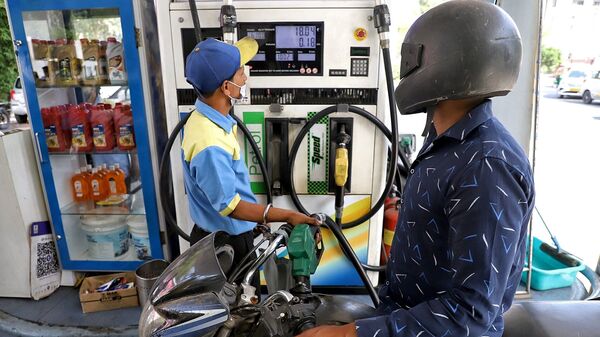 Documentary photo of a gas station employee refueling a two-wheeler.  (Amit Sharma)