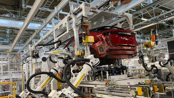 The robotic arm feeds into the electric vehicle powertrain on the Ariya model on the assembly line at the Nissan plant in Japan.  (AP)