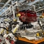Robotic arms put in the electric vehicle powertrain into the Ariya model in the assembly line at a Nissan plant in Japan. (AP)
