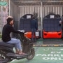 A man sits on his electric scooter as he waits to swap his battery at a Sun Mobility battery swapping station in New Delhi. (Representational photo) (REUTERS)