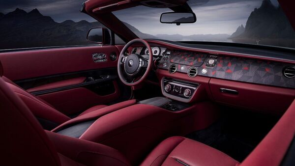 The interior of the Rolls-Royce La Rose Noire Droptail is minimalist with just three primary buttons on the curved shawl-style wooden dashboard and matching champagne chest. Majority of the controls are located in the center console. The interior of the Rolls-Royce La Rose Noire Droptail is minimalist with just three primary buttons on the curved shawl-style wooden dashboard and matching champagne chest. Majority of the controls are located in the center console.