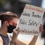 A protester holds a sign during a demonstration outside of the California Public Utilities Commission (CPUC) in San Francisco. (Getty Images via AFP)