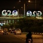 G20 logos are illuminated with the colors of the Indian flag on a pedestrian bridge in New Delhi, India. (AP)