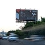 Vehicles speed past a billboard showing India's maiden MotoGP event to be held between September 22 and 24 at the Buddh International Circuit in Greater Noida. (AFP)