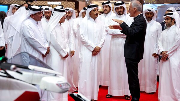 French engineer Ludovic Lazareth (R) introduces the Lazareth LMV 496 flying motorcycle to Qatar's Prime Minister Mohammed bin Abdulrahman bin Jassim al-Thani (C) during the opening ceremony of the Geneva International Motor Show (GIMS) at the Doha Exhibition and Convention Center in Doha. flying motorcycle