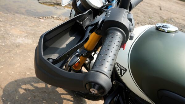 Triumph has not only made cosmetic changes to the Scrambler 400 X but there are mechanical changes as well. The motorcycle comes with a larger front wheel, knuckle guards, a headlight grille, a bash plate, a split seat setup and a split grab rail. There is a new exhaust unit on the side as well. It is a dual-barrel unit and it does sound better than the exhaust found on the Speed 400. Triumph has not only made cosmetic changes to the Scrambler 400 X but there are mechanical changes as well. The motorcycle comes with a larger front wheel, knuckle guards, a headlight grille, a bash plate, a split seat setup and a split grab rail. There is a new exhaust unit on the side as well. It is a dual-barrel unit and it does sound better than the exhaust found on the Speed 400.