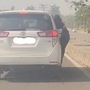 Snapshot of the woman hanging from moving car's door (X/@Vivek K. Tripathi)