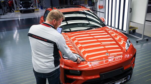 An employee checks a new Porsche Macan 4 Electric model at the final inspection of the production site at German car producer Porsche AG in Leipzig, eastern Germany.