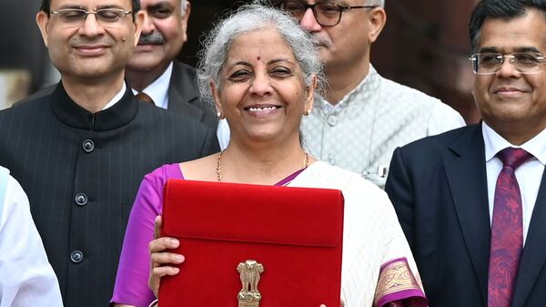 Union Finance Minister Nirmala Sitharaman showcases a red pouch carrying the Budget documents, outside the Finance Ministry in North Block.