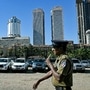 A security personnel walks past a fleet of abandoned vehicles, including luxury car like Toyota Land Cruiser and Range Rover, in Colombo. These abandoned vehicles include those also owned by the government. Hundreds of pricey government vehicles have been abandoned around Sri Lanka's capital after the country's new Marxist-leaning president took office. (AFP)