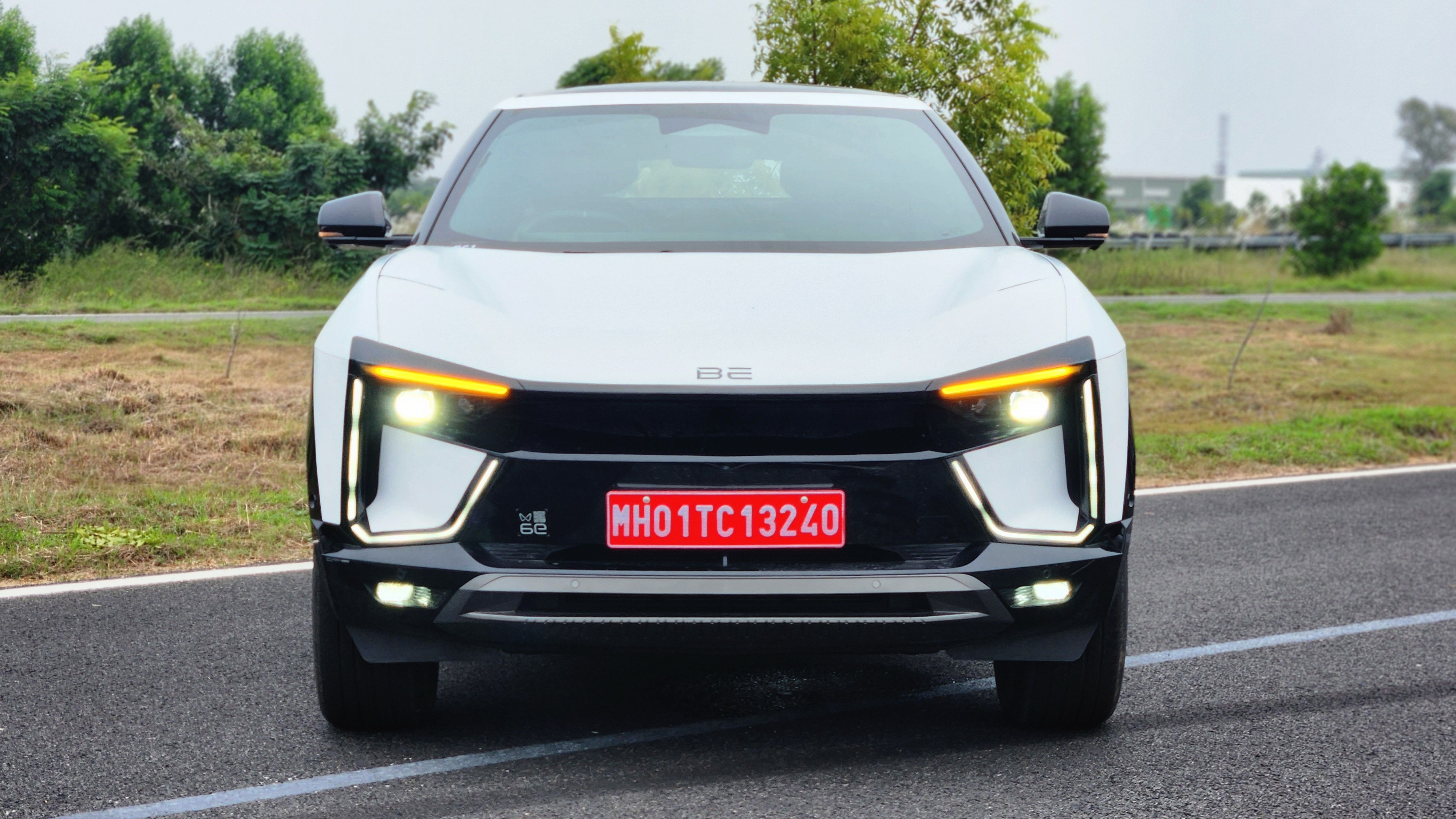 A look at the front face of the Mahindra BE 6e electric SUV with its unique design highlighted by a scooped bonnet, LED DRL signature and headlight units and gloss black bumper housing the fog lights.