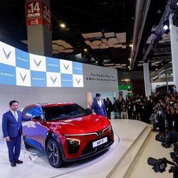 Pham Sanh Chau, VinFast's India CEO, and Ashwin Patil, Deputy CEO of VinFast India, pose with the VF 7 electric SUV at the Auto Expo 2025. The VF 7 and VF 6 are the first two electric cars the Vietnam-based EV maker plans to launch in India. (REUTERS)
