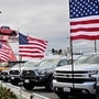 US flags fly outside a car dealership in Alhambra, California, on March 27, 2025. Automakers were battered on March 27 as stock markets fell on both sides of the Atlantic after US President Donald Trump announced significant tariffs on imported vehicles and parts, pressing ahead with tough trade policies many fear will spark a recession. (Photo by Frederic J. BROWN / AFP) (AFP)