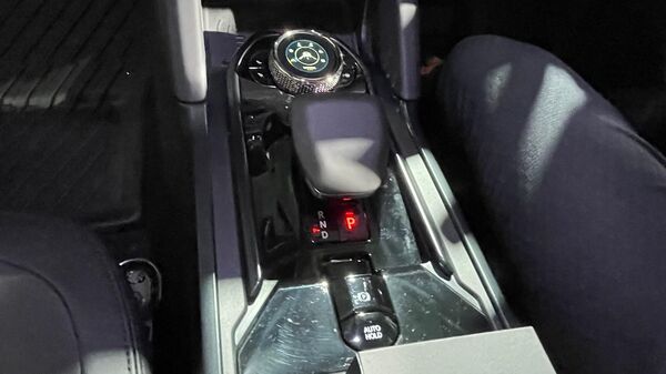 Looking lower at the central console, there is an electric shift lever, an electronic parking brake with auto hold and a know type terrain mode selector. This selector allows switching between six different modes including normal, sand, mud ruts, snow/grass, rock crawl and custom. Looking lower at the central console, there is an electric shift lever, an electronic parking brake with auto hold and a know type terrain mode selector. This selector allows switching between six different modes including normal, sand, mud ruts, snow/grass, rock crawl and custom.