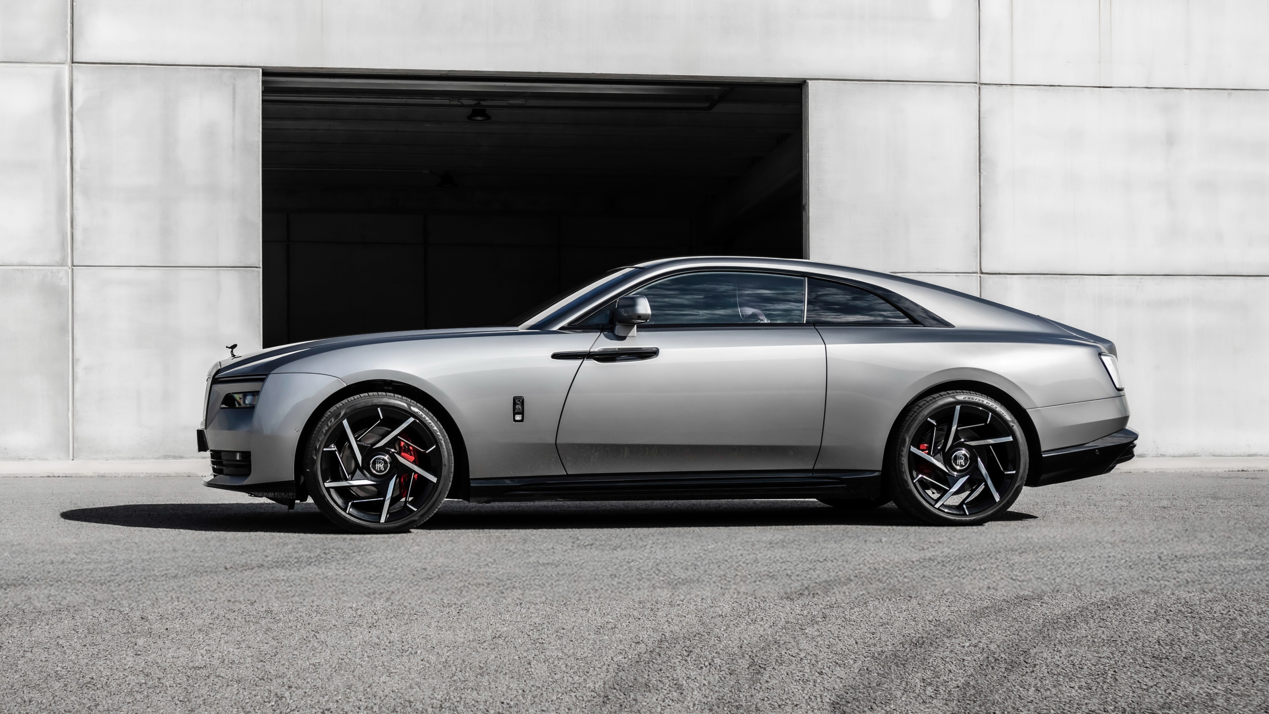 The Rolls-Royce Spectre Black Badge adds a dark chrome finish on the Pantheon grille, bumpers, and the Spirit of Ecstasy. The two-door EV rides on new 23-inch forged aluminium wheels Rolls-Royce Spectre Black Badge