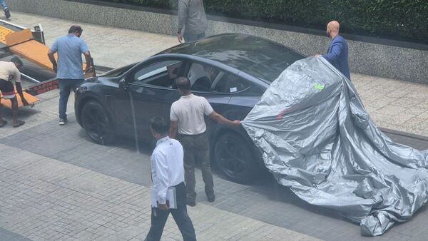 One of the first EVs is being unloaded near the new experience centre of Tesla.