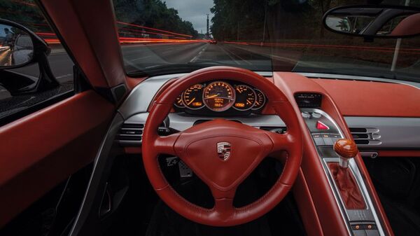 The Carrera GT's cabin is treated with soft leather, Recaro bucket seats, and a beachwood gearknob positioned right next to the steering wheel Porsche Carrera GT