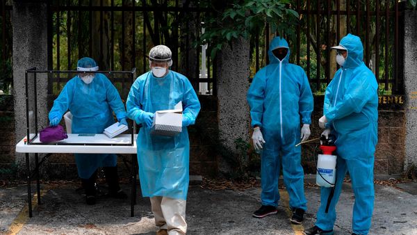 Health workers prepare to conduct a COVID-19 coronavirus test at a walk-thru testing station set up outside the Legislative Assembly building, to test employees and members of the legislature in San Salvador on April 24, 2020. (Photo by Yuri CORTEZ / AFP) (AFP) Health workers prepare to conduct a COVID-19 coronavirus test at a walk-thru testing station set up outside the Legislative Assembly building, to test employees and members of the legislature in San Salvador on April 24, 2020. (Photo by Yuri CORTEZ / AFP) (AFP)